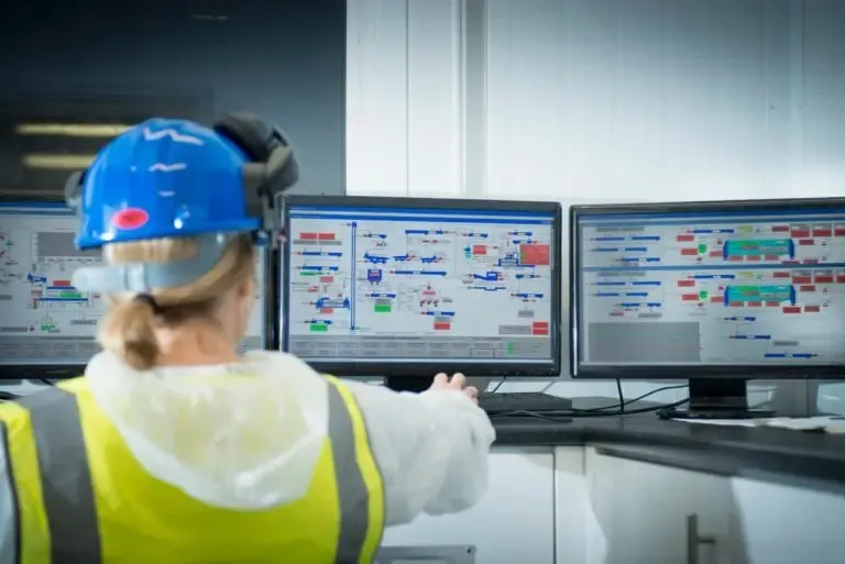 Ingeniero operando interfaz HMI en un centro de control SCADA para automatización industrial