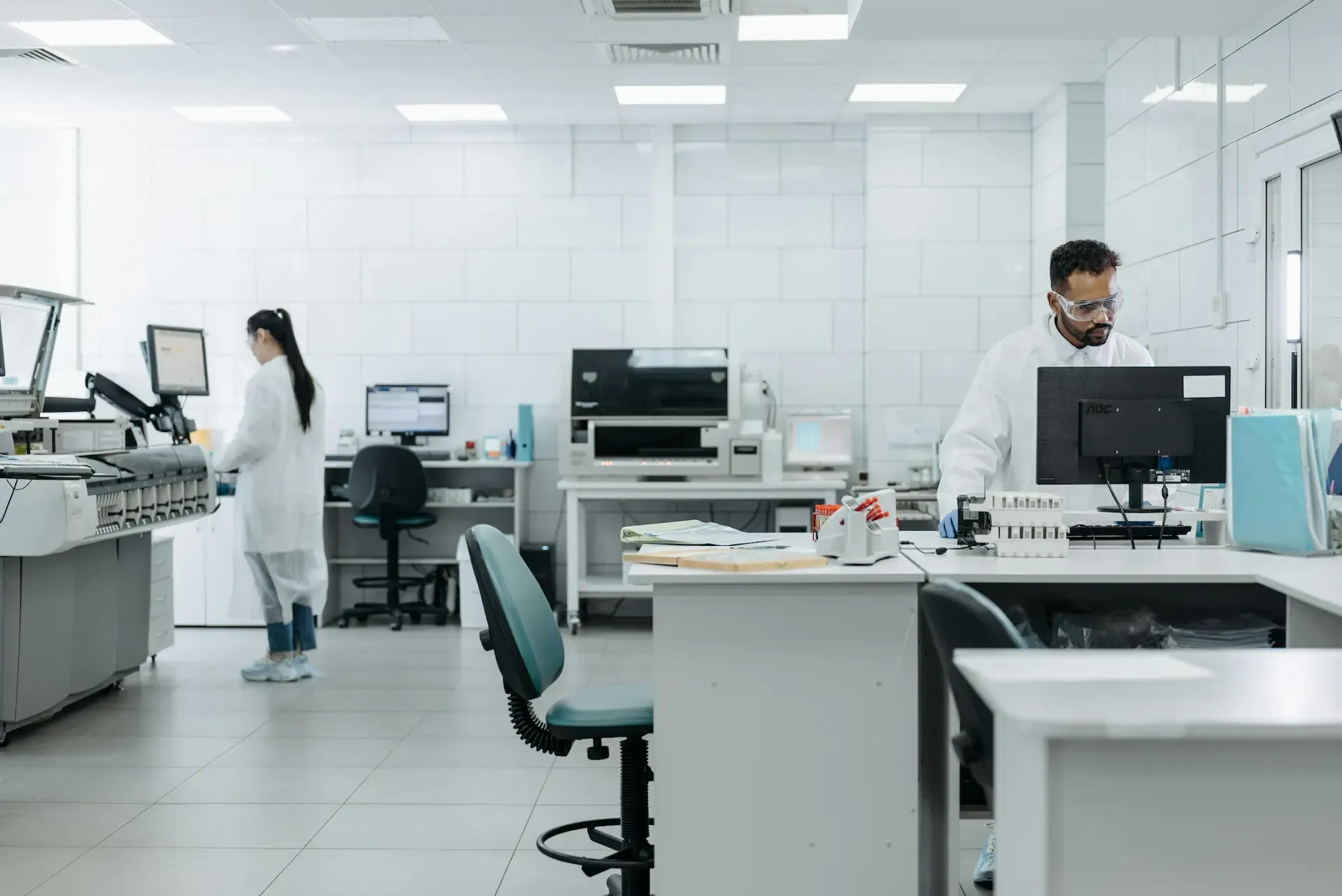 Operador documentando variables críticas de producción en un cuarto limpio farmacéutico mediante un sistema SCADA